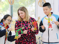 A foreign friend from South Africa is experiencing Chinese shadow play with primary school children in Qingdao, Shandong Province, China, on...