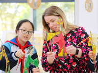 A foreign friend from South Africa is experiencing Chinese shadow play with primary school children in Qingdao, Shandong Province, China, on...