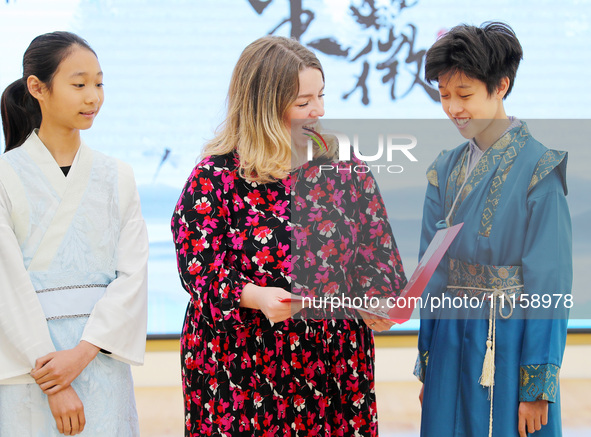 A foreign friend from South Africa is reciting ancient Chinese poetry with primary school children in Qingdao, Shandong Province, China, on...