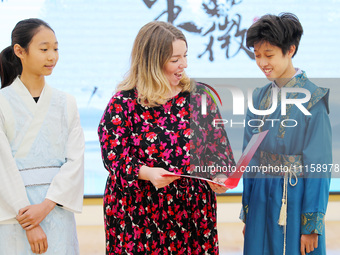 A foreign friend from South Africa is reciting ancient Chinese poetry with primary school children in Qingdao, Shandong Province, China, on...