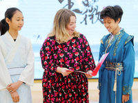 A foreign friend from South Africa is reciting ancient Chinese poetry with primary school children in Qingdao, Shandong Province, China, on...