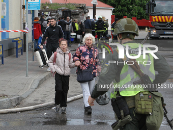 Residents are standing outside the apartment block that was damaged by the Russian missile attack in Dnipro, Ukraine, on April 19, 2024. (