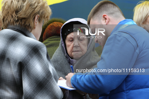 Residents are standing outside the apartment block that was damaged by the Russian missile attack in Dnipro, Ukraine, on April 19, 2024. 