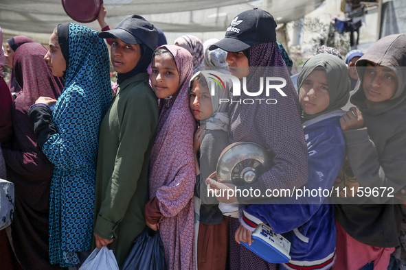 Displaced Palestinians are gathering to receive food at a donation point in Deir al-Balah, central Gaza Strip, on April 19, 2024, amid ongoi...