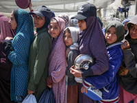 Displaced Palestinians are gathering to receive food at a donation point in Deir al-Balah, central Gaza Strip, on April 19, 2024, amid ongoi...