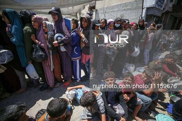 Displaced Palestinians are gathering to receive food at a donation point in Deir al-Balah, central Gaza Strip, on April 19, 2024, amid ongoi...