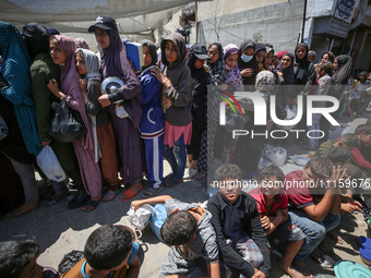 Displaced Palestinians are gathering to receive food at a donation point in Deir al-Balah, central Gaza Strip, on April 19, 2024, amid ongoi...