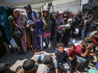 Displaced Palestinians are gathering to receive food at a donation point in Deir al-Balah, central Gaza Strip, on April 19, 2024, amid ongoi...