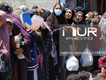 Displaced Palestinians are gathering to receive food at a donation point in Deir al-Balah, central Gaza Strip, on April 19, 2024, amid ongoi...