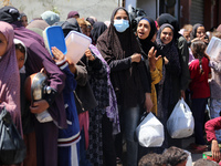 Displaced Palestinians are gathering to receive food at a donation point in Deir al-Balah, central Gaza Strip, on April 19, 2024, amid ongoi...