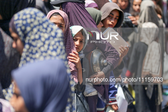 Displaced Palestinians are gathering to receive food at a donation point in Deir al-Balah, central Gaza Strip, on April 19, 2024, amid ongoi...