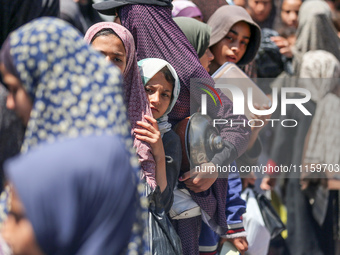 Displaced Palestinians are gathering to receive food at a donation point in Deir al-Balah, central Gaza Strip, on April 19, 2024, amid ongoi...