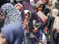 Displaced Palestinians are gathering to receive food at a donation point in Deir al-Balah, central Gaza Strip, on April 19, 2024, amid ongoi...