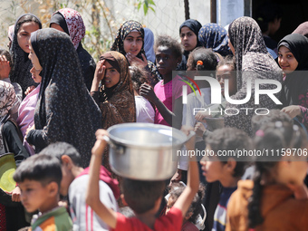 Displaced Palestinians are gathering to receive food at a donation point in Deir al-Balah, central Gaza Strip, on April 19, 2024, amid ongoi...