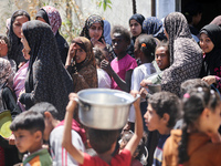 Displaced Palestinians are gathering to receive food at a donation point in Deir al-Balah, central Gaza Strip, on April 19, 2024, amid ongoi...