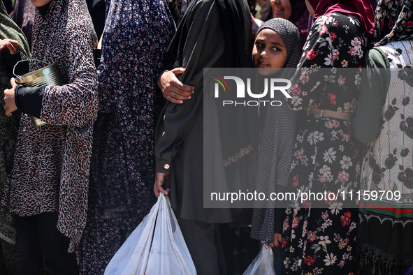 Displaced Palestinians are gathering to receive food at a donation point in Deir al-Balah, central Gaza Strip, on April 19, 2024, amid ongoi...