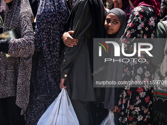 Displaced Palestinians are gathering to receive food at a donation point in Deir al-Balah, central Gaza Strip, on April 19, 2024, amid ongoi...