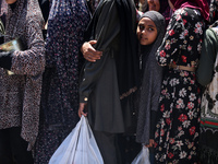 Displaced Palestinians are gathering to receive food at a donation point in Deir al-Balah, central Gaza Strip, on April 19, 2024, amid ongoi...