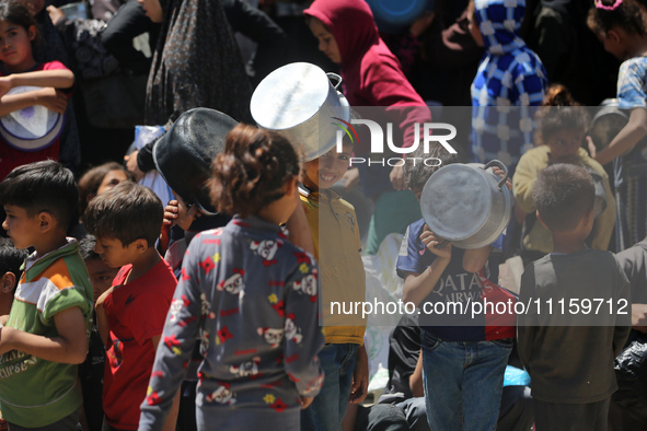 Displaced Palestinians are gathering to receive food at a donation point in Deir al-Balah, central Gaza Strip, on April 19, 2024, amid ongoi...