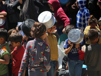 Displaced Palestinians are gathering to receive food at a donation point in Deir al-Balah, central Gaza Strip, on April 19, 2024, amid ongoi...