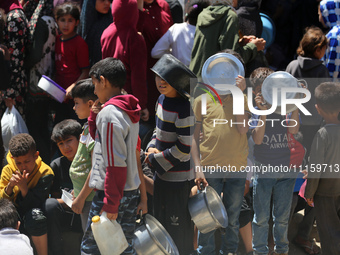 Displaced Palestinians are gathering to receive food at a donation point in Deir al-Balah, central Gaza Strip, on April 19, 2024, amid ongoi...