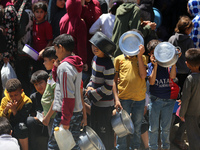 Displaced Palestinians are gathering to receive food at a donation point in Deir al-Balah, central Gaza Strip, on April 19, 2024, amid ongoi...