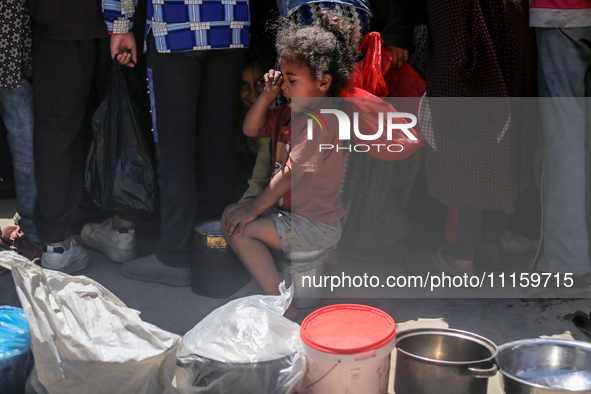 Displaced Palestinians are gathering to receive food at a donation point in Deir al-Balah, central Gaza Strip, on April 19, 2024, amid ongoi...