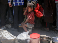 Displaced Palestinians are gathering to receive food at a donation point in Deir al-Balah, central Gaza Strip, on April 19, 2024, amid ongoi...