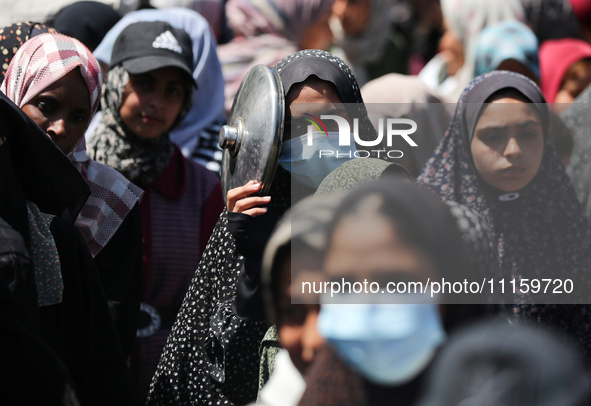 Displaced Palestinians are gathering to receive food at a donation point in Deir al-Balah, central Gaza Strip, on April 19, 2024, amid ongoi...