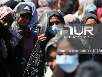 Displaced Palestinians are gathering to receive food at a donation point in Deir al-Balah, central Gaza Strip, on April 19, 2024, amid ongoi...