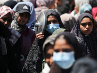 Displaced Palestinians are gathering to receive food at a donation point in Deir al-Balah, central Gaza Strip, on April 19, 2024, amid ongoi...