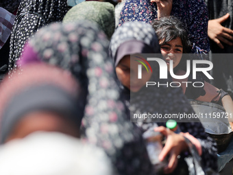 Displaced Palestinians are gathering to receive food at a donation point in Deir al-Balah, central Gaza Strip, on April 19, 2024, amid ongoi...