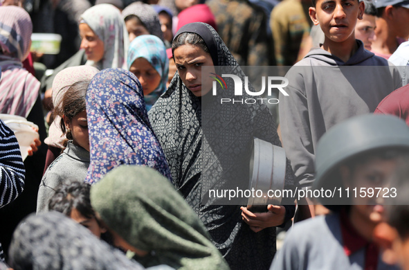 Displaced Palestinians are gathering to receive food at a donation point in Deir al-Balah, central Gaza Strip, on April 19, 2024, amid ongoi...