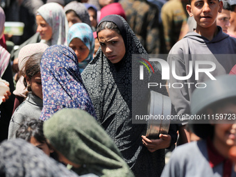 Displaced Palestinians are gathering to receive food at a donation point in Deir al-Balah, central Gaza Strip, on April 19, 2024, amid ongoi...