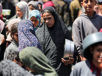 Displaced Palestinians are gathering to receive food at a donation point in Deir al-Balah, central Gaza Strip, on April 19, 2024, amid ongoi...