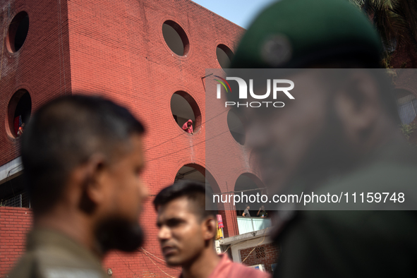 A woman is peering out from a window after a fire broke out in the intensive care unit of the Dhaka Shishu (Children) Hospital in Dhaka, Ban...