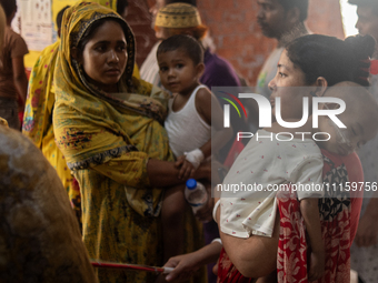 Women are holding their children while standing outside the Dhaka Shishu (Children) Hospital after a fire broke out inside the intensive car...