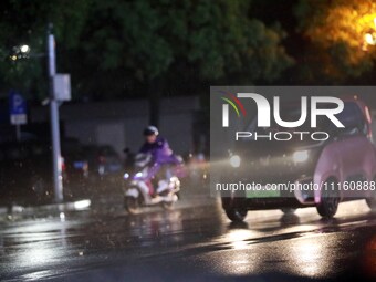 People are riding along a waterlogged road in Chang'an town, Rongan County, Liuzhou City, Guangxi Zhuang Autonomous Region, South China, on...