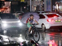 People are riding along a waterlogged road in Chang'an town, Rongan County, Liuzhou City, Guangxi Zhuang Autonomous Region, South China, on...