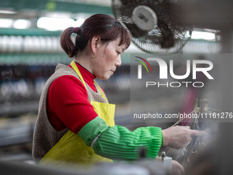 A worker is drawing silk at a mulberry silk processing workshop in Xinghua, China, on April 20, 2024. (