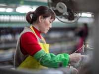 A worker is drawing silk at a mulberry silk processing workshop in Xinghua, China, on April 20, 2024. (