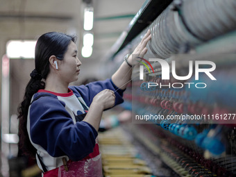 A worker is drawing silk at a mulberry silk processing workshop in Xinghua, China, on April 20, 2024. (