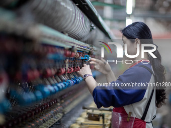 A worker is drawing silk at a mulberry silk processing workshop in Xinghua, China, on April 20, 2024. (