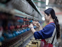 A worker is drawing silk at a mulberry silk processing workshop in Xinghua, China, on April 20, 2024. (