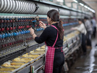 A worker is drawing silk at a mulberry silk processing workshop in Xinghua, China, on April 20, 2024. (