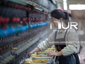 A worker is drawing silk at a mulberry silk processing workshop in Xinghua, China, on April 20, 2024. (