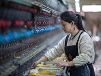 A worker is drawing silk at a mulberry silk processing workshop in Xinghua, China, on April 20, 2024. (