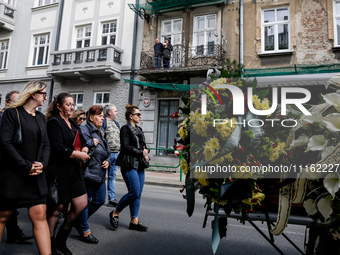 Family and friends walk in a funeral procession as residents on a balcony send they respects during funeral of Damian Sobol, a volunteer for...