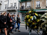 Family and friends walk in a funeral procession as residents on a balcony send they respects during funeral of Damian Sobol, a volunteer for...