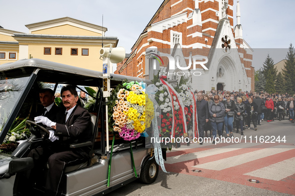 Family and friends walk in a funeral procession as they attend a funeral of Damian Sobol, a volunteer for World Central Kitchen, who was kil...